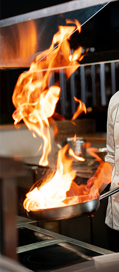 The chef cooks shrimp in a pan